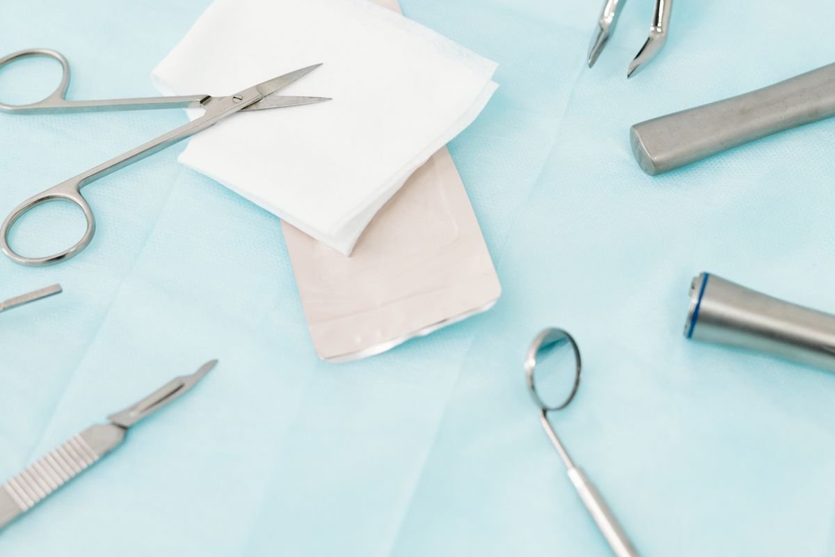 Instrumentos cirúrgicos odontológicos esterilizados sobre campo azul