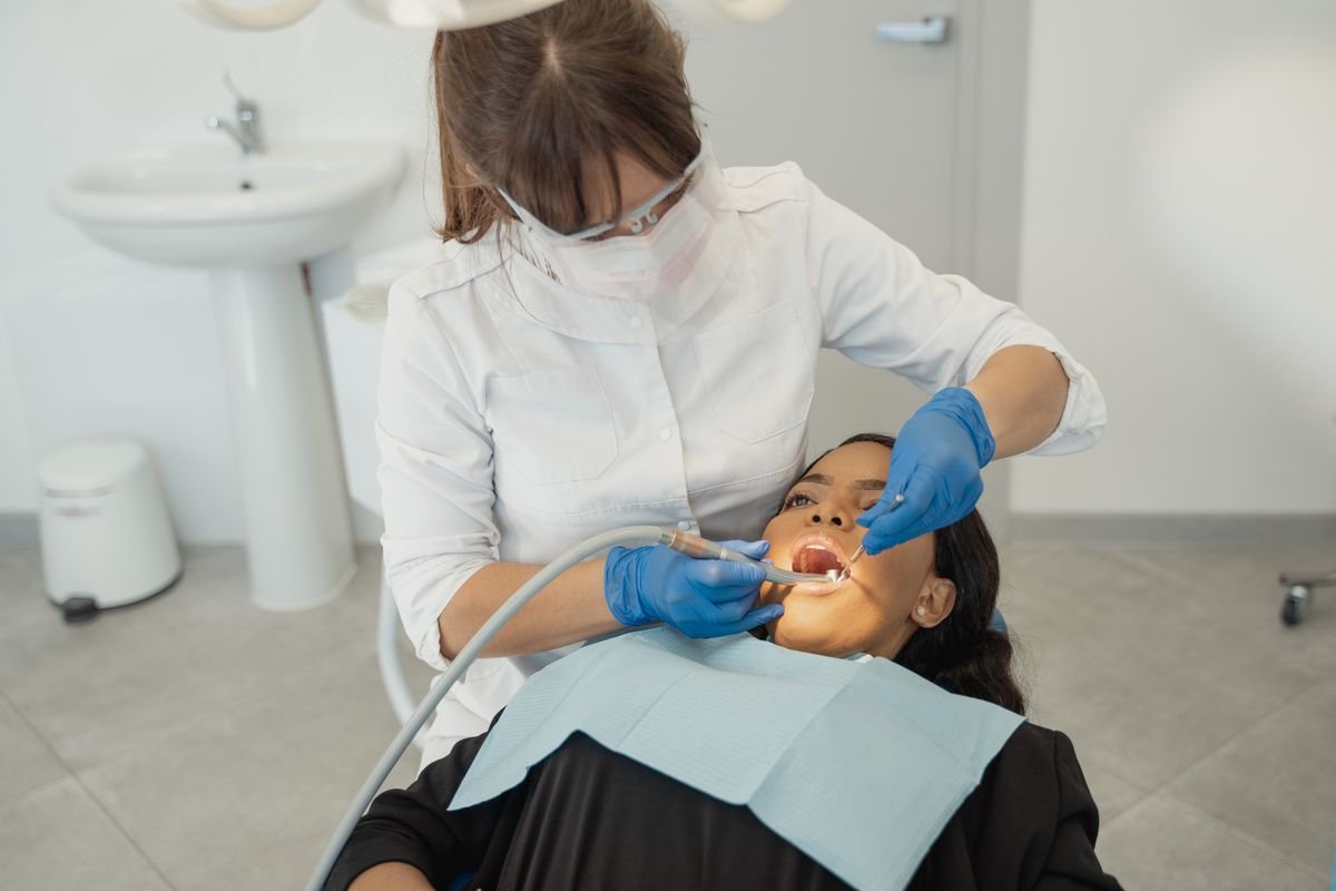Dentista examinando uma paciente na primeira consulta