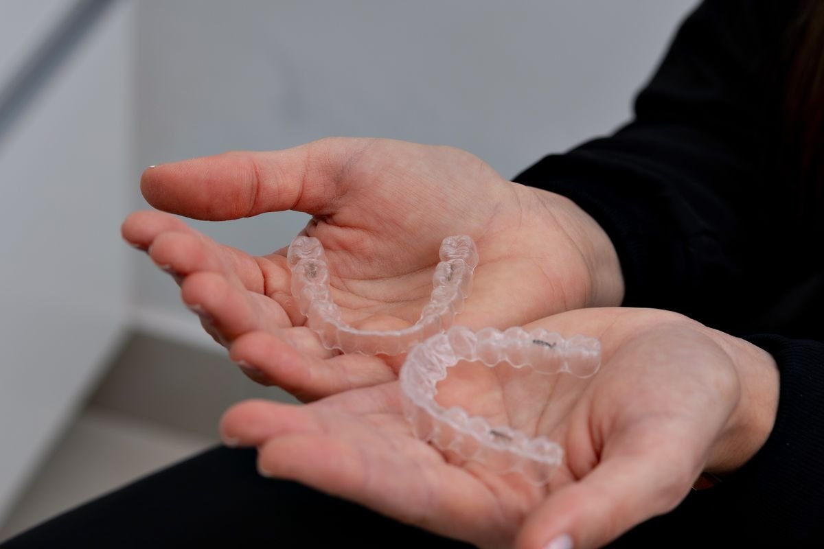 Alinhadores ortodônticos transparentes nas mãos de uma profissional