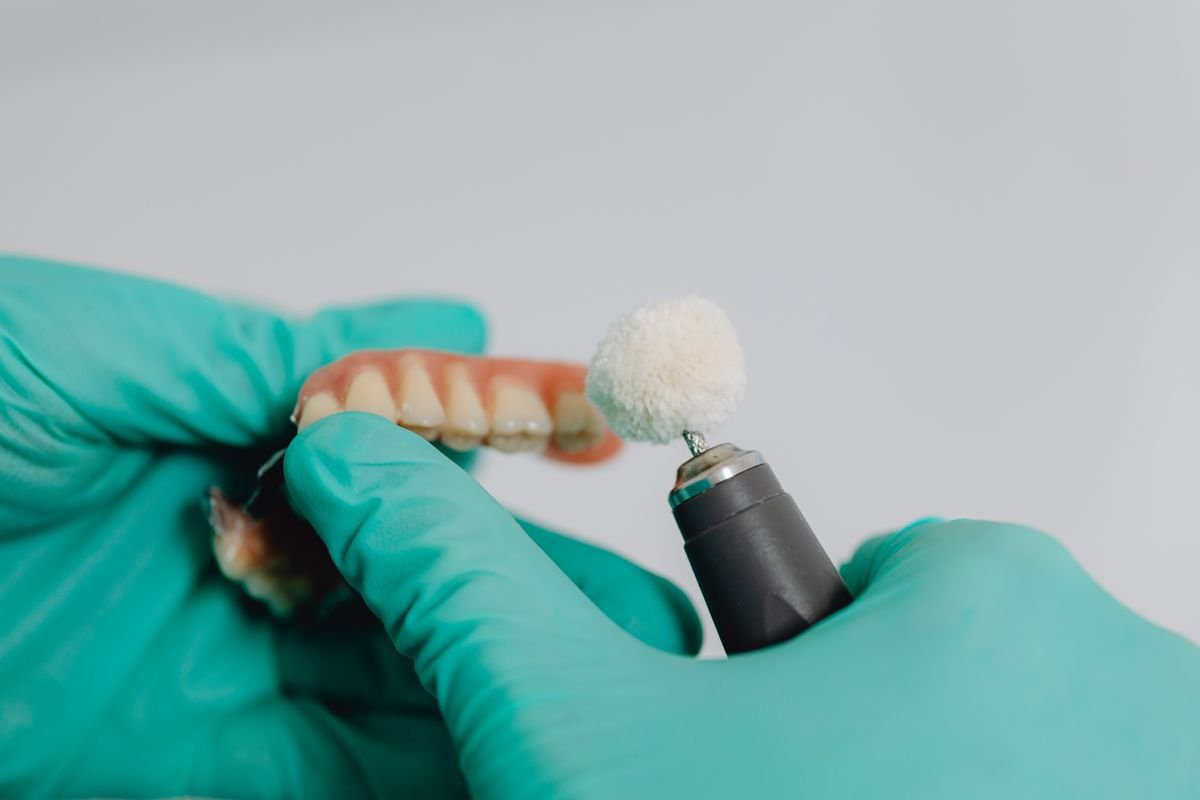 Prótese dentária sendo polida em laboratório
