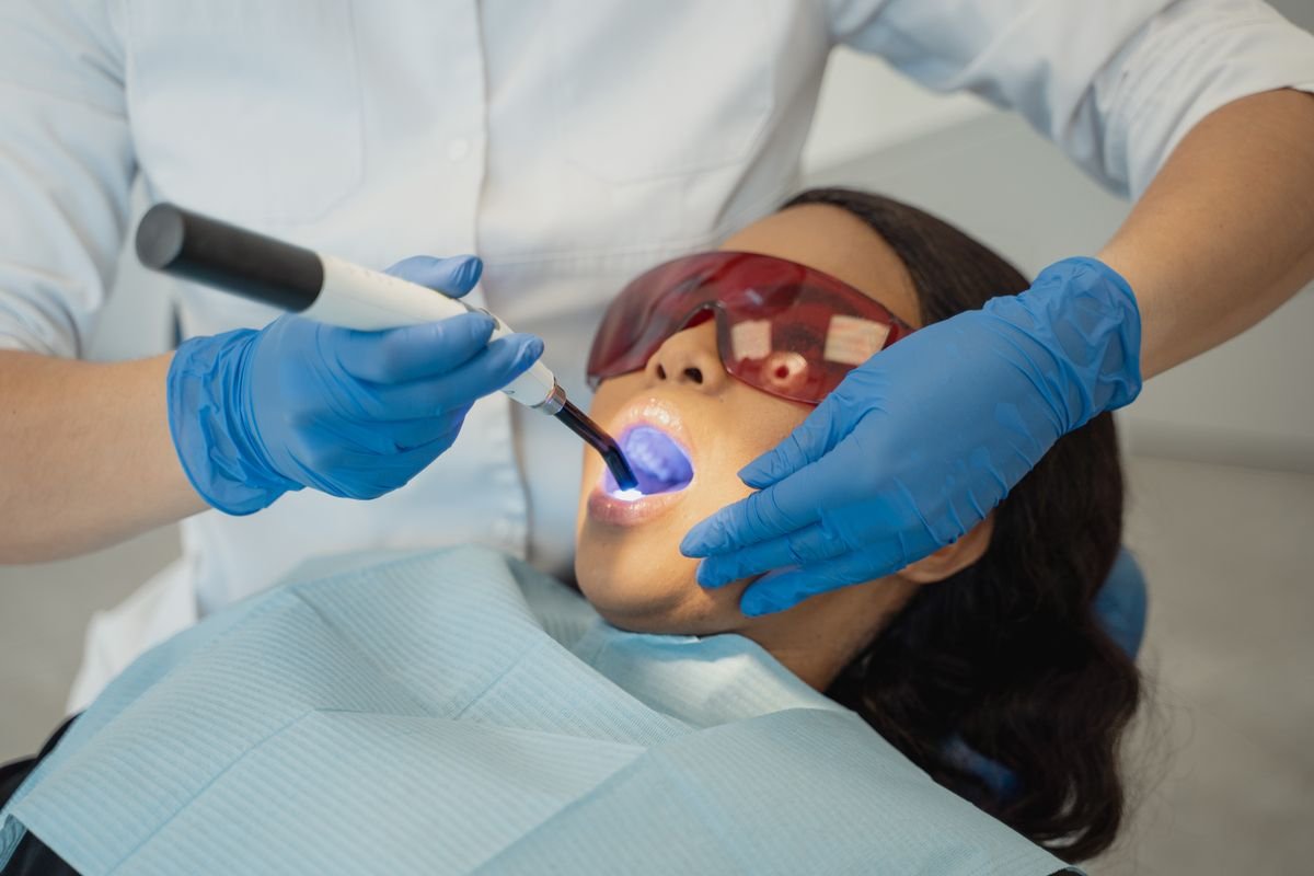 Restauração dental sendo fotopolimerizada com luz de LED