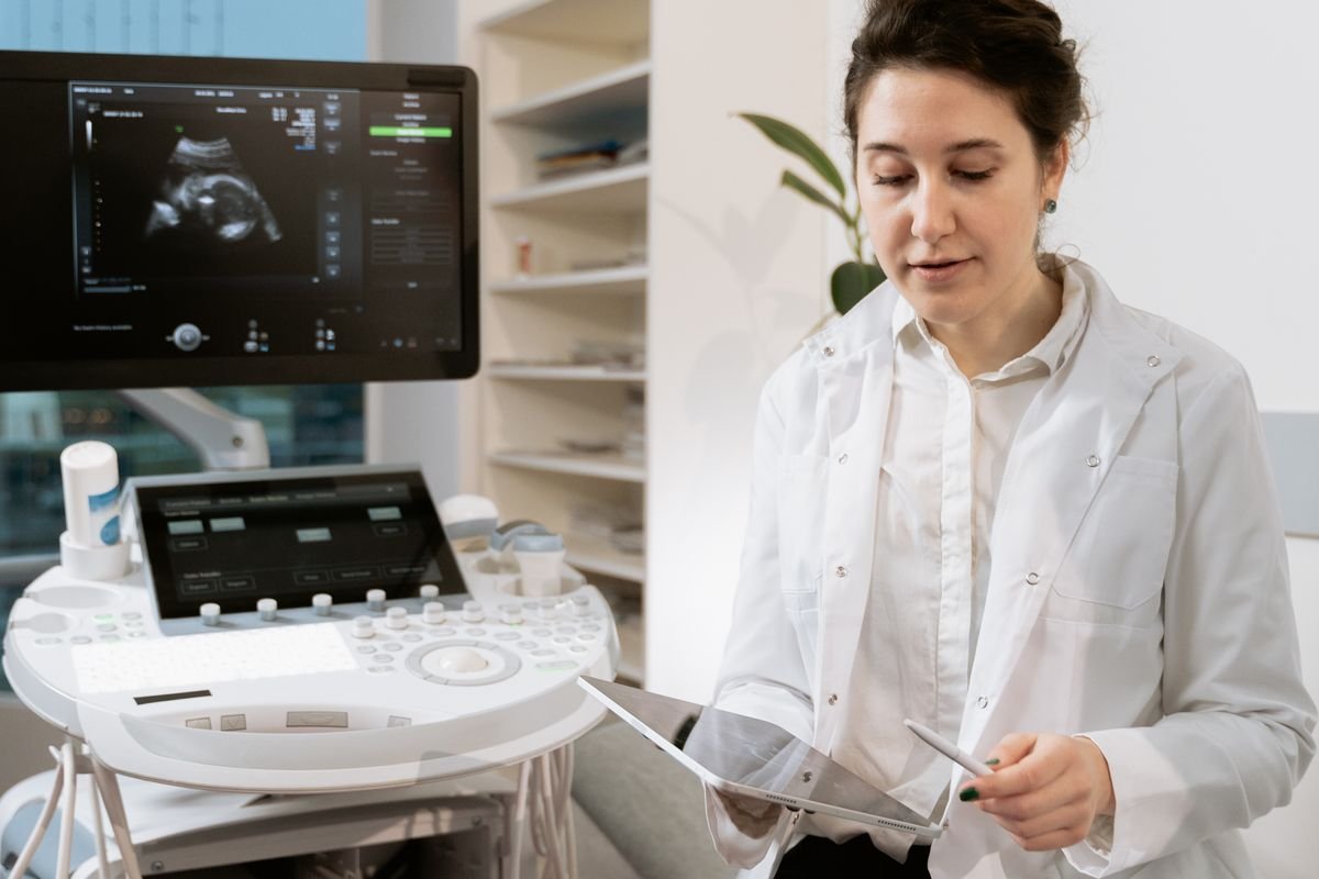 Médica ao lado do aparelho de ultrassom no consultório